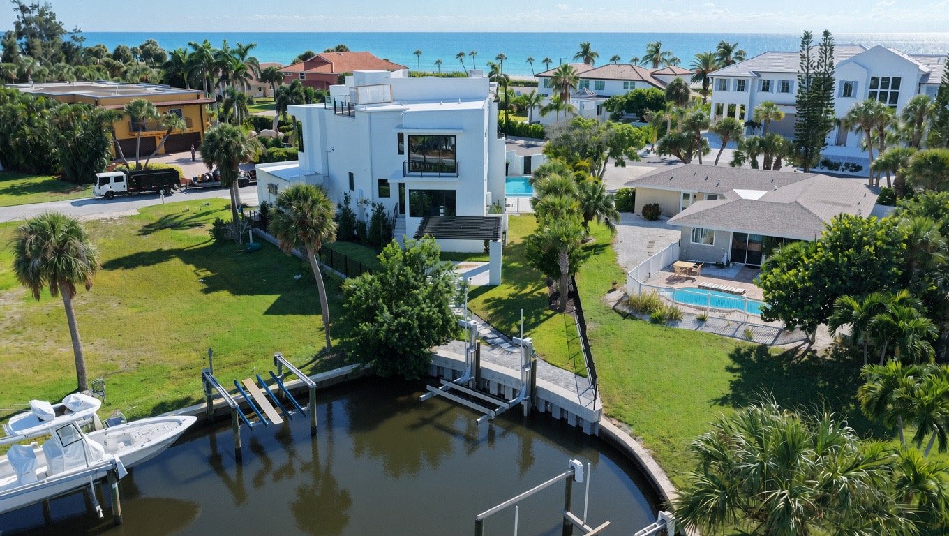 From the canal: dock and boat lift, pool and the house, the Gulf beyond