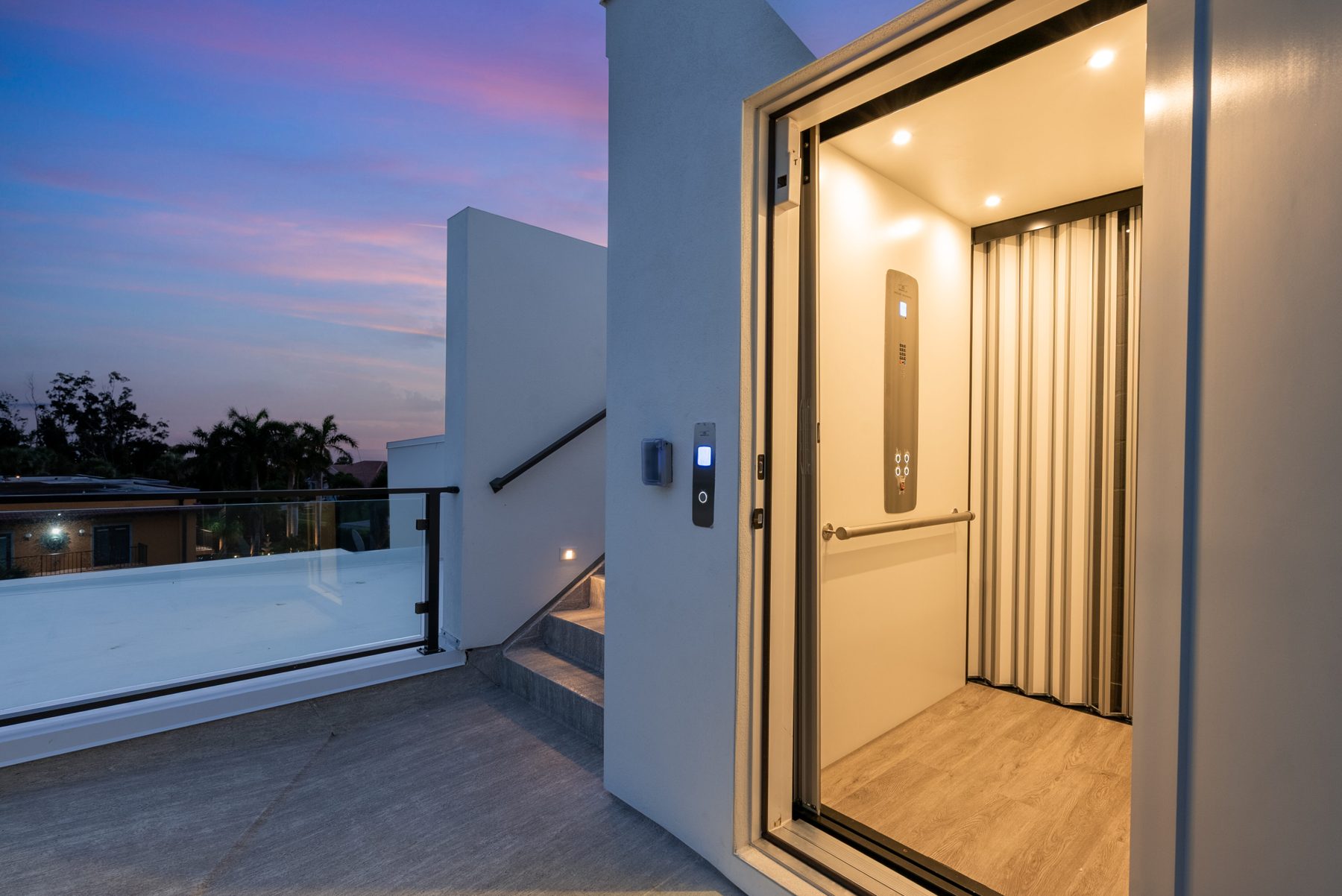 Elevator opening onto the rooftop terrace at dusk